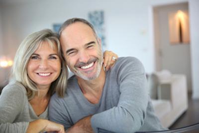 older couple smiling & hugging with bright smiles I same-day dental crowns fayetteville ar