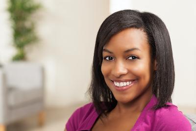 A black woman smiling after a teeth whitening treatment in Fayetteville, AR