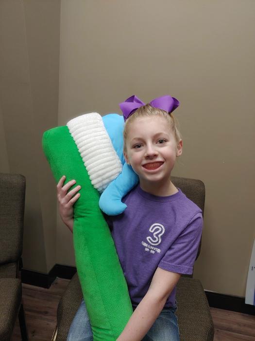Young dental patient with toothbrush l Fayetteville AR Dentist