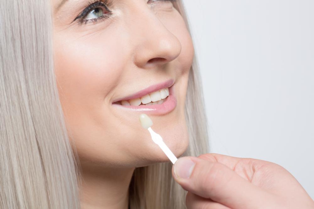 Image of dentist checking veneer fitment against patients teeth