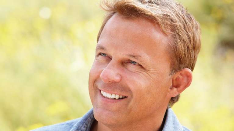 Blonde man staring away revealing his white teeth in Arkansas