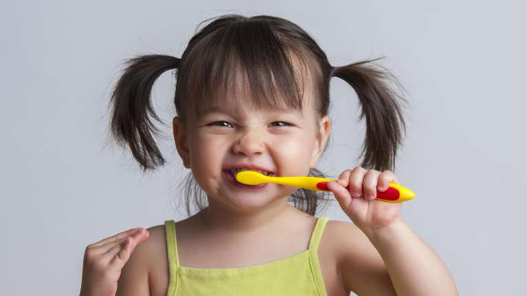 child brushing her teeth