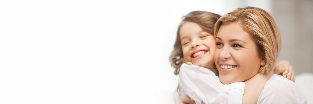 Young mother & daughter smiling & hugging l Kid's Dentist Fayetteville AR