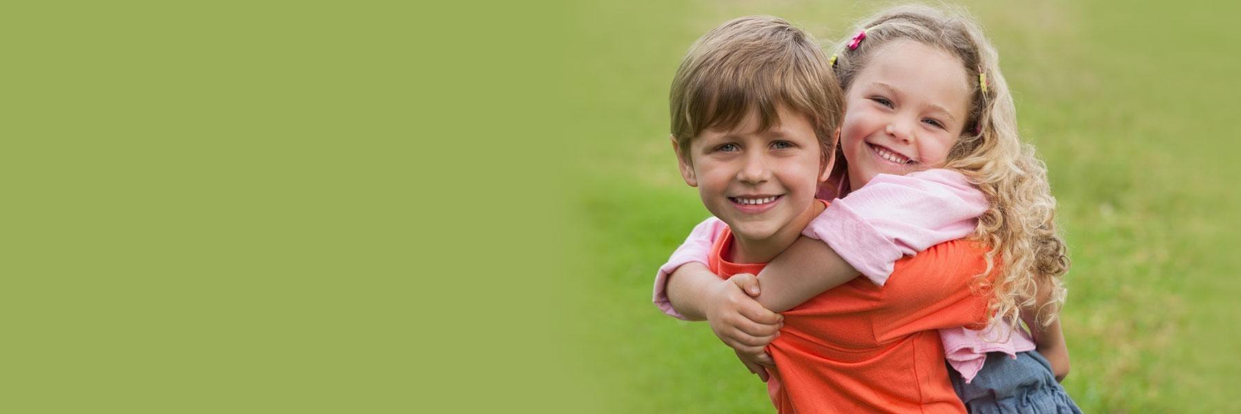 Two young children hugging & smiling l Preventive Dentist Fayetteville AR